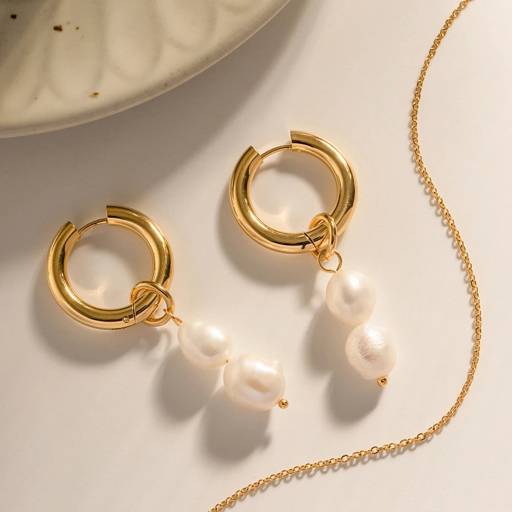 A pair of Ellen Dual Pearl Pendant Earrings featuring stainless steel construction for durability, showcasing a classic and timeless design with dual pearl pendants.